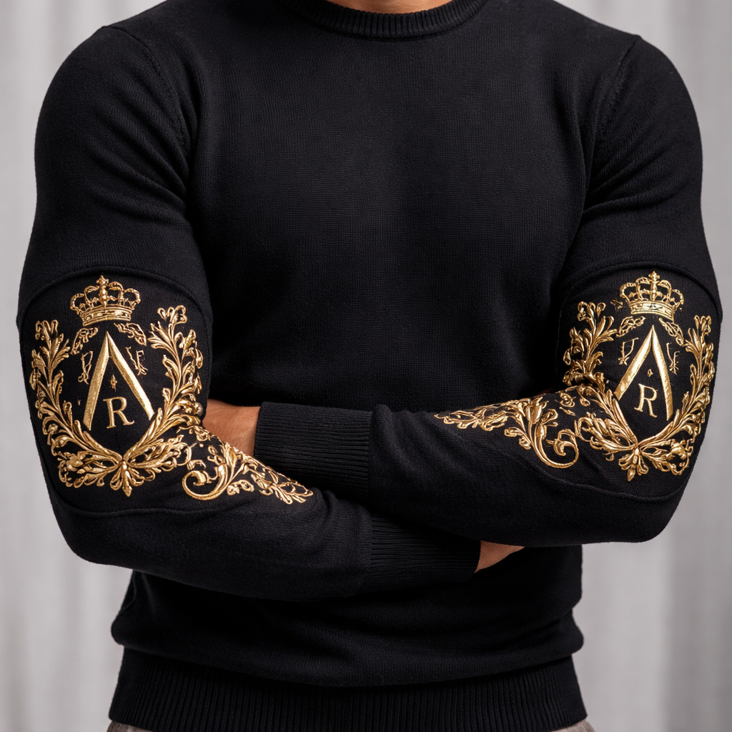 I am designing a man’s long sleeve wool slim fit top.
Only on the forearms I want my crest which is sureounded by heraldry filigree all headed by a crown
In the centre of the crest is a Lambda upper case Λ.
inside the Λ is a Christian cross
On one side of the crosses flanks is the letter R and on the other side thr letter C. This is all inside THE Λ not outside it
There is a heraldry crown above the Λ
Placement: Epaulettes
Because the design is situated on the forearm area, it mimics the "epaulette" or "forearm found on Roman Empire and Spartan traditional armour. In this case, it appears to be a raised panel that has been integrated into the knit of the sweater to provide a structural base for the decoration.
2. Technique: Bullion Embroidery
The style of the gold work is likely Bullion Wire Embroidery (also known as Goldwork). This is a traditional method used for military crests and high-end heraldry.
• It uses fine wire threads (often gold or silver-plated) rather than standard polyester or rayon thread.
• It creates a high-relief, 3D effect that is far more rigid and reflective than standard flat embroidery.
3. Application: Patch vs. Direct
Looking at the edges of the gold crest, it is most likely a Pre-made Embroidered Patch (Appliqué) that has been stitched onto the forearm panel.
• Why a patch? High-density bullion work is very heavy. Embroidering it directly onto a flexible knit sweater would cause the fabric to sag or pucke
It has to be on the forearms NOT UPPER ARMS AND NO WHERE ELSE
I am designing a man’s long sleeve wool slim fit top.
Only on the forearms I want my crest which is sureounded by heraldry filigree all headed by a crown
In the centre of the crest is a Lambda upper case Λ.
inside the Λ is a Christian cross
On one side of the crosses flanks is the letter R and on the other side thr letter C. This is all inside THE Λ not outside it
There is a heraldry crown above the Λ
Placement: Epaulettes
Because the design is situated on the forearm area, it mimics the "epaulette" or "forearm found on Roman Empire and Spartan traditional armour. In this case, it appears to be a raised panel that has been integrated into the knit of the sweater to provide a structural base for the decoration.
2. Technique: Bullion Embroidery
The style of the gold work is likely Bullion Wire Embroidery (also known as Goldwork). This is a traditional method used for military crests and high-end heraldry.
• It uses fine wire threads (often gold or silver-plated) rather than standard polyester or rayon thread.
• It creates a high-relief, 3D effect that is far more rigid and reflective than standard flat embroidery.
3. Application: Patch vs. Direct
Looking at the edges of the gold crest, it is most likely a Pre-made Embroidered Patch (Appliqué) that has been stitched onto the forearm panel.
• Why a patch? High-density bullion work is very heavy. Embroidering it directly onto a flexible knit sweater would cause the fabric to sag or pucke
It has to be on the forearms NOT UPPER ARMS AND NO WHERE ELSE