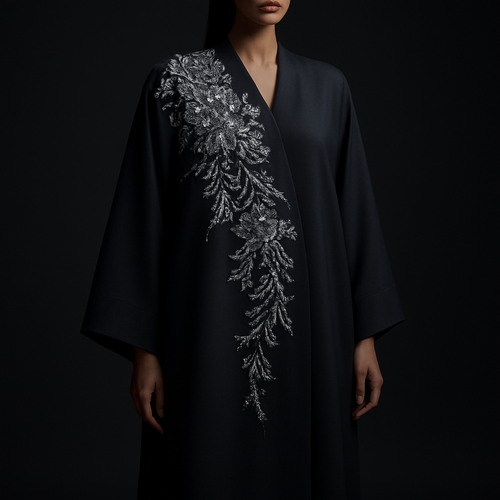 The Platinum Night Bloom Abaya
Tone: Midnight black or midnight grey
Design:
Asymmetric platinum floral embroidery concentrated on one shoulder.
Embellishment:
Platinum crystals giving a cool, expensive shimmer.
Vibe: Cold luxury, bold and unforgettable.