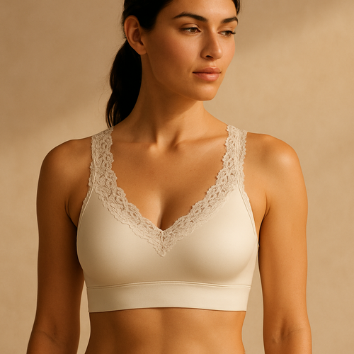Athletic woman (170 cm, 58 kg, natural curves, C-cup) wearing a luxury ivory sports bra made from high-performance satin stretch fabric with delicate lace edging on neckline and straps. Refined floral lace detail, soft matte sheen, seamless contour, photographed in warm natural daylight on a beige background.”