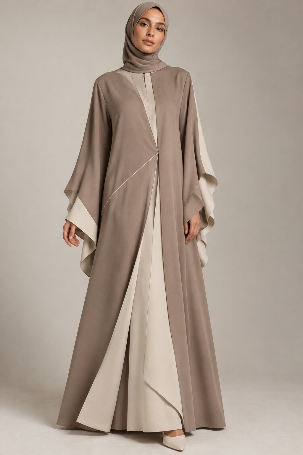 Create an original luxury modest fashion abaya design for a premium contemporary brand. Floor-length elegant silhouette, innovative asymmetrical overlapping front panels, sculptural flowing sleeves, refined geometric seam details, hidden front closure, premium matte crepe fabric, sophisticated warm taupe and ivory color palette. Modest, timeless, feminine and distinctive design. Full-body female fashion model, front view, realistic fabric texture, luxury fashion editorial photography, clean neutral studio background. Avoid common mass-market designs and excessive embellishments. Show the garment clearly.
Create an original luxury modest fashion abaya design for a premium contemporary brand. Floor-length elegant silhouette, innovative asymmetrical overlapping front panels, sculptural flowing sleeves, refined geometric seam details, hidden front closure, premium matte crepe fabric, sophisticated warm taupe and ivory color palette. Modest, timeless, feminine and distinctive design. Full-body female fashion model, front view, realistic fabric texture, luxury fashion editorial photography, clean neutral studio background. Avoid common mass-market designs and excessive embellishments. Show the garment clearly.